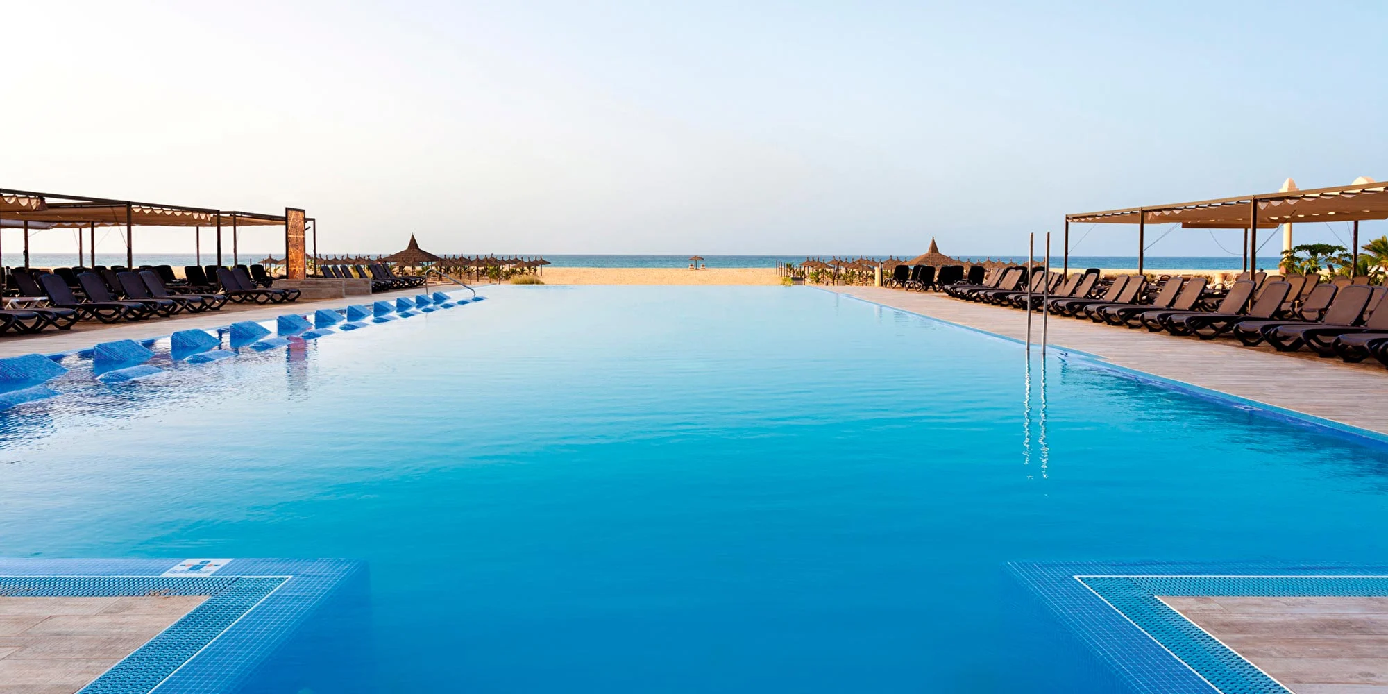 Zwembad met palmbomen bij een luxe RIU resort in de zon